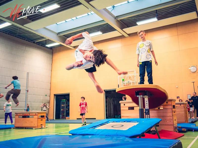 Kind macht einen Rückwärtssalto vom Trampolin im WEMOVE.-Kurs