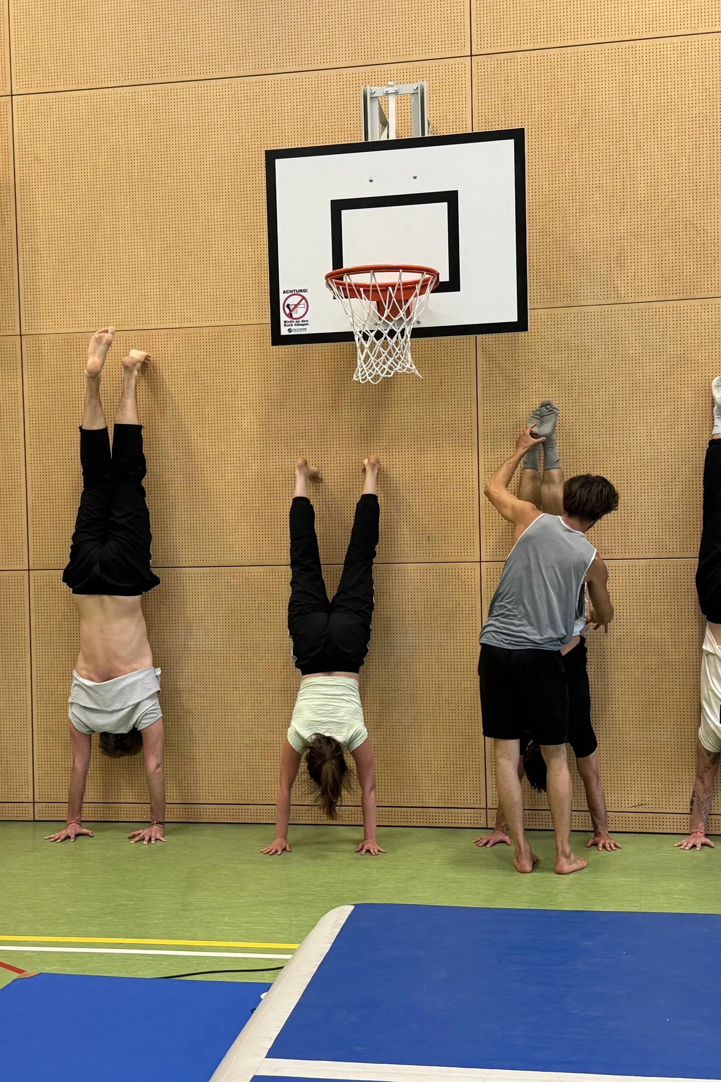 Gruppe im Handstand an der Hallenwand